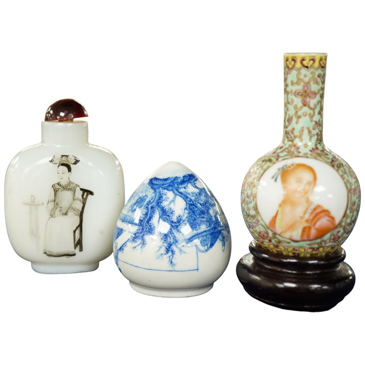 A Chinese enamelled white glass snuff bottle, a blue and white bird feeder and a famille rose vase, the first 9cm